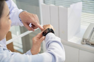 Doktor kadın kıdemli sağlık app akıllı seyretmek nasıl açıklayan