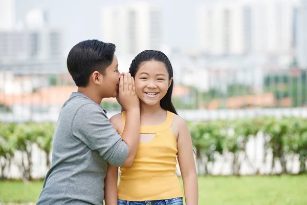 两个亚洲孩子在户外 男孩告诉女孩一个秘密 — 图库照片