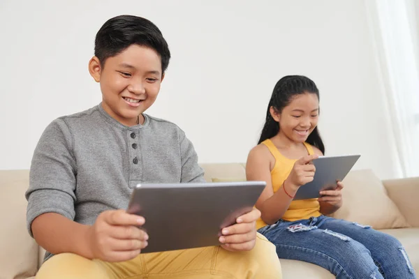 Due Bambini Asiatici Sul Divano Casa Bambini Che Navigano Tablet — Foto Stock