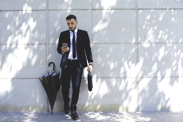 Bonito Empresário Com Guarda Chuva Ler Mensagens Telefone Celular Parede — Fotografia de Stock