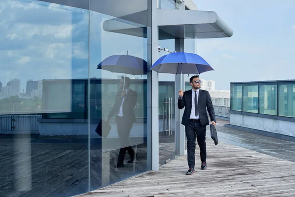 Elegante Man Wandelen Buurt Van Glazen Gebouw Met Blauwe Paraplu — Stockfoto