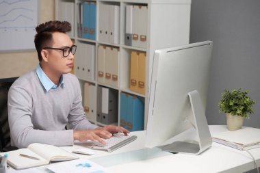 Genç işadamı çalışma ofisinde bilgisayarda ile meşgul