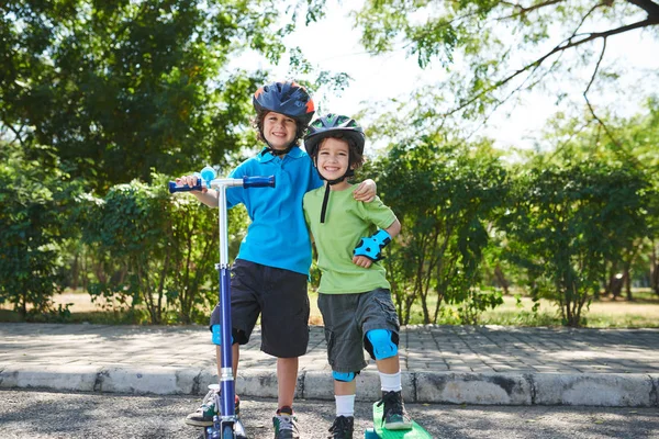 Two hugging happy smiling brothers in helmets