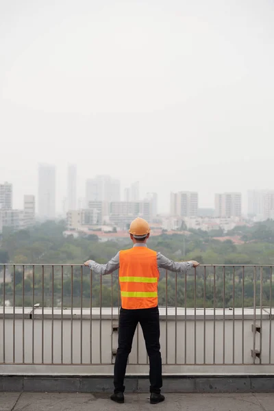 Pracownik Budowlany Zamyślony Jasne Kamizelka Patrząc Miasto — Zdjęcie stockowe