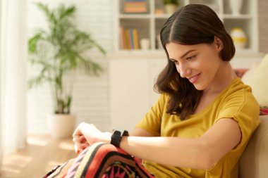 Güzel gülümseyen genç kadın akıllı kol saati zamanında kontrol