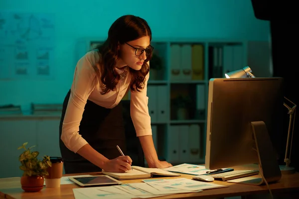 商务妇女在黑暗的办公室房间工作在桌与计算机 写在日志里 — 图库照片
