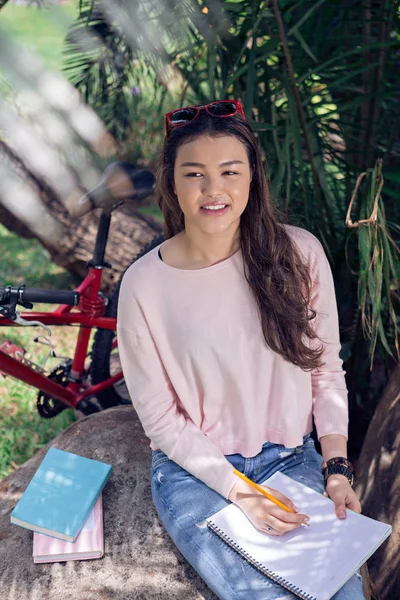 Chica Escribiendo Diario Mientras Está Sentado Bajo Árbol Con Bicicleta —  Fotos de Stock