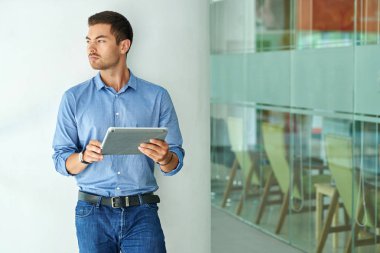 Yakışıklı dalgın işadamı uygulama üzerinde dijital tablet kullanma