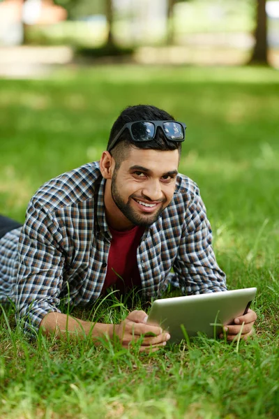 Leende Indisk Man Liggande Grön Gräsmatta Och Poserar För Fotografering — Stockfoto