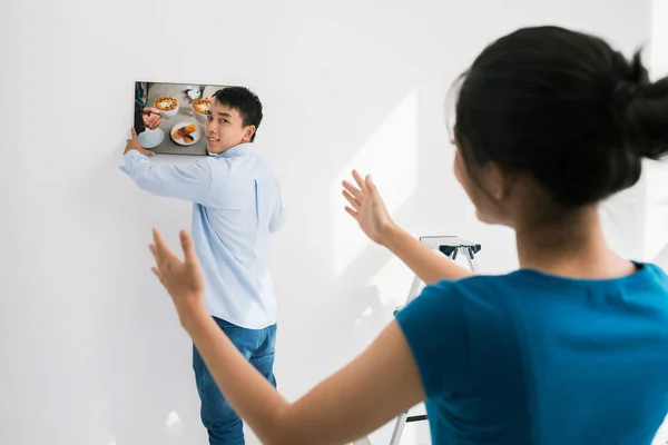 若いアジアのカップルの部屋で壁の写真をぶら下げ — ストック写真