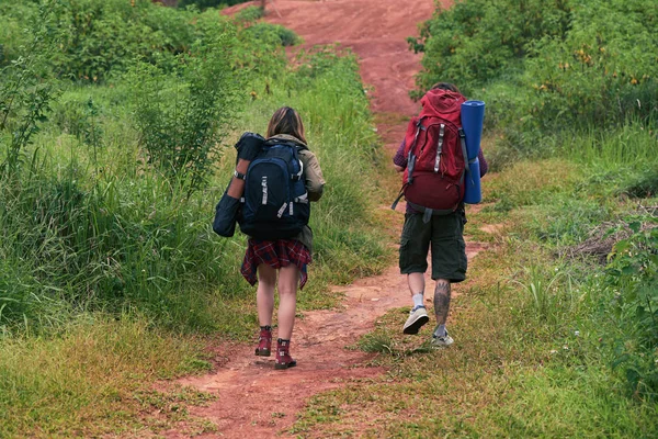 Rückansicht Von Jungen Wanderern Mit Rucksäcken Die Buschigen Gelände Entlang — Stockfoto