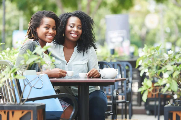 美丽的非洲裔美国妇女在户外咖啡咖啡馆与咖啡杯 妇女看着相机和微笑 — 图库照片
