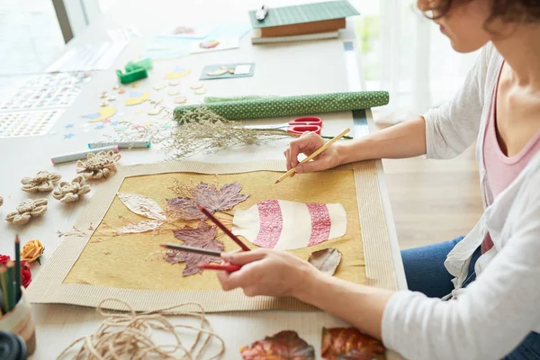ahşap masada oturan ve sulak dekor sanat resim yapma kadın 