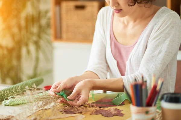 ahşap masada oturan ve sulak dekor sanat resim yapma Tasarımcı kadın 