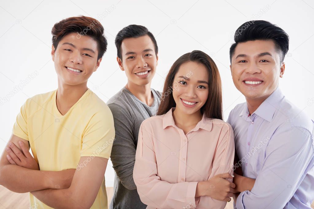 Happy smiling asian people standing with arms crossed and posing on camera 