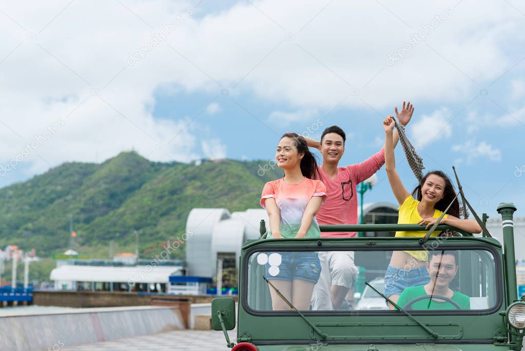 Group of friends traveling by car on summer holidays