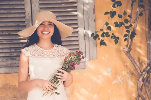 Romantic Asian Lady Dress Hat Standing Yellow Wall Holding Flowers — Stock Photo, Image