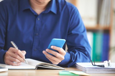 Elinde bir şey smartphone ve not almak gönüllülük işadamı