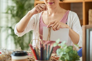Yaratıcı kadın dize karton dikdörtgenin etrafında kaydırma