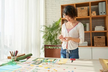 Gülümseyen Asyalı kadın dekoratif öğeler için tebrik kartları yapmak