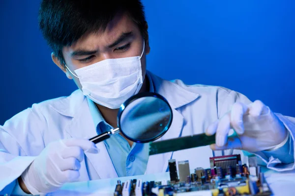 Asiatischer Elektronikingenieur Blickt Durch Lupe Auf Motherboard — Stockfoto