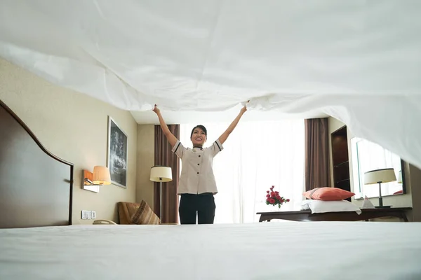 Taze Battaniye Yatağın Üstüne Koyarak Gülümseyen Asyalı Hizmetçi — Stok fotoğraf