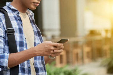 adam açık havada ayakta iken cep telefonunuzu kullanarak kırpılmış görüntü 