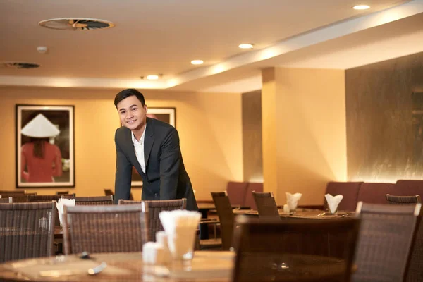 テーブル チェックの若いアジア レストランのオーナーの笑顔 — ストック写真