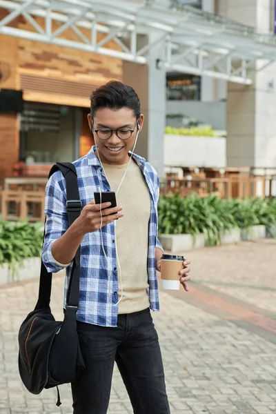 Sorrindo Homem Asiático Fones Ouvido Navegando Smartphone Segurando Caneca Café — Fotografia de Stock