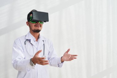 beyaz ceket modern ofiste çalışırken Vr kulaklık giyen adam