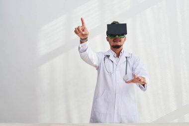 adam beyaz ceket giyiyor Vr kulaklık modern ofiste çalışırken parmak işaret 
