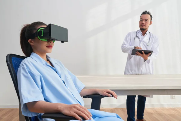 Smiling Young Nurse Sitting Cozy Chair Using Headset While Confident — Stock Photo, Image