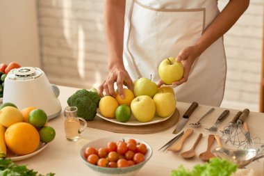 mutfak masasında giyen önlük kalan tanınmaz halde kadın ve malzemeler için taze yeşil salata hazırlık