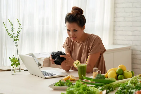 現代のカメラに彼女のビデオブログを自宅で作業中の写真を見てかなりアジア食品のブロガー — ストック写真