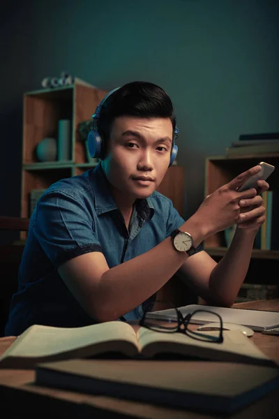 Bonito Homem Asiático Com Smartphone Sentado Sua Mesa Casa — Fotografia de Stock