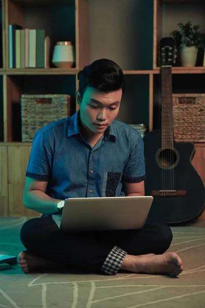 Joven Hombre Vietnamita Sentado Suelo Habitación Trabajando Ordenador Portátil —  Fotos de Stock