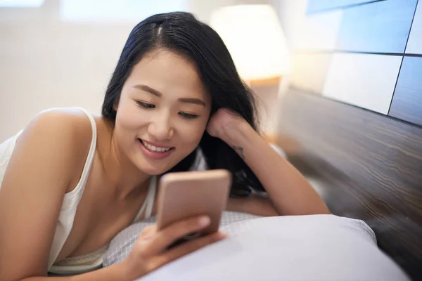 Young Relaxed Asian Woman Using Smartphone While Cuddling Bed Morning — Stock Photo, Image