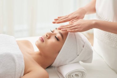 Anonim kadın elele çekici kadın müvekkilinin yüz spa oturum sırasında salonda