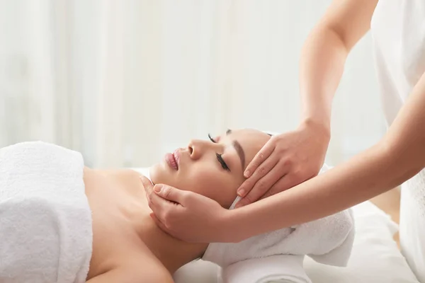 Anonieme Therapeut Wrijven Gezicht Van Aantrekkelijke Vrouwelijke Client Tijdens Massage — Stockfoto