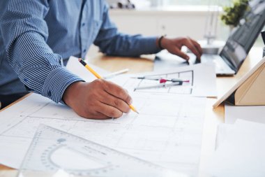 Planı üzerinde çalışma ve dizüstü bilgisayar kullanma office ürün Hintli adam yan görünüm