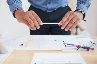 Ofiste planlar ve belgeler ile akıllı telefon çekimi kırpma tanınmayan adam