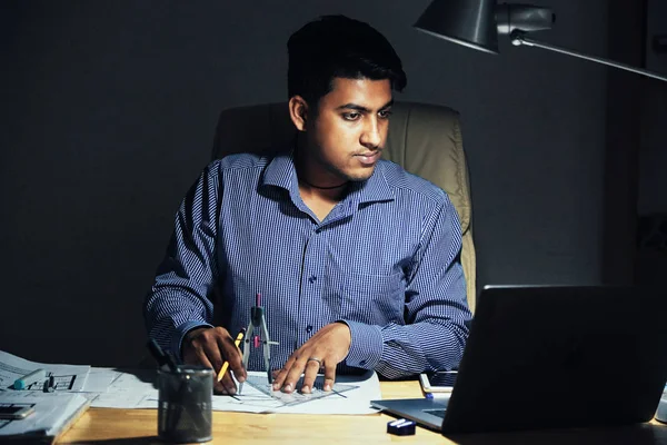 Adult Indian Architect Looking Laptop Drawing Blueprint While Having Overtime — Stock Photo, Image