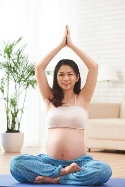 Güzel bir Vietnamlı genç kadın evde yoga uygulamak