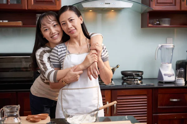 年轻美丽的亚洲女性站在厨房里互相拥抱 对着镜头微笑的肖像 — 图库照片