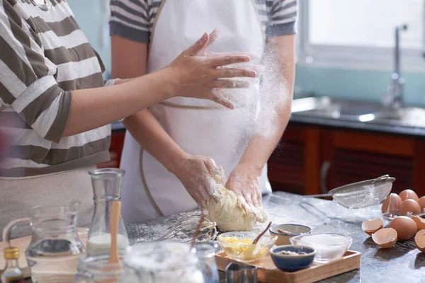 認識できない女性から彼女の手をオフにダスティングの作物ショットは台所のテーブルに別の混練生地ながら小麦粉します — ストック写真