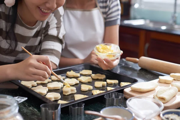 Vista Cerca Mujeres Anónimas Aplicando Mantequilla Galletas Crudas Cortadas Acostadas — Foto de Stock