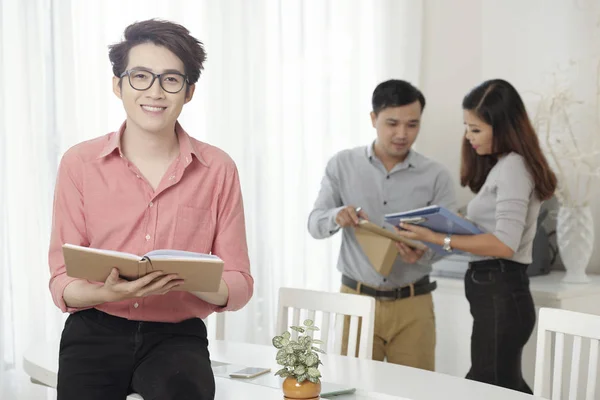 Sonriente Joven Hombre Étnico Gafas Sosteniendo Libro Mientras Está Pie — Foto de Stock