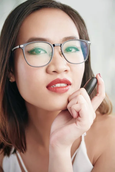 赤い口紅を保持している眼鏡のセクシーな美しいアジアの女性 — ストック写真