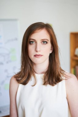 Ciddi görünümlü kameraya ofiste iş yerinde güzel beyaz bir kadın portresi