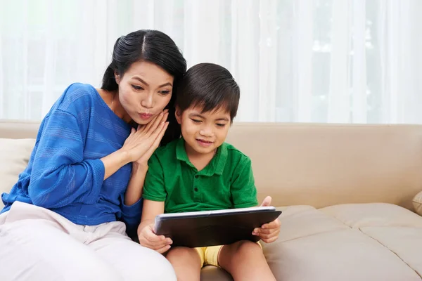 彼の母親にタブレット コンピューターでアジア少年示す漫画 — ストック写真
